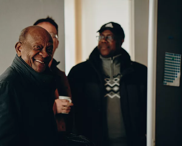 Kleine, gut gelaunte Menschengruppe steht im Kreis 