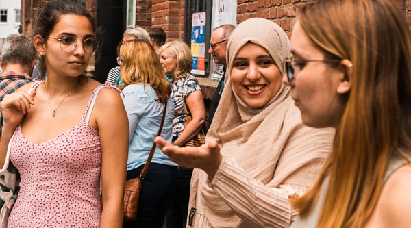 Eine Gruppe Frauen steht in der Sonne vor der KoFabrik in Bochum.