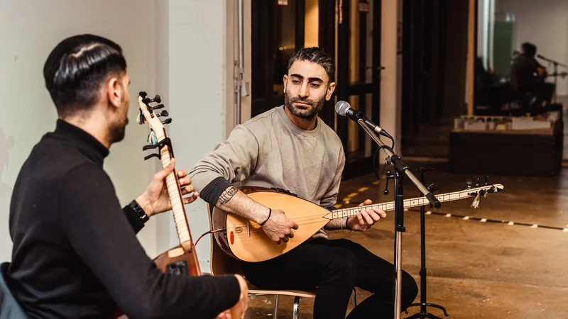 Fröhliche Menschen spielen gemeinsam drinnen Gitarre