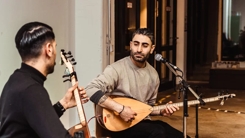 Fröhliche Menschen spielen gemeinsam drinnen Gitarre