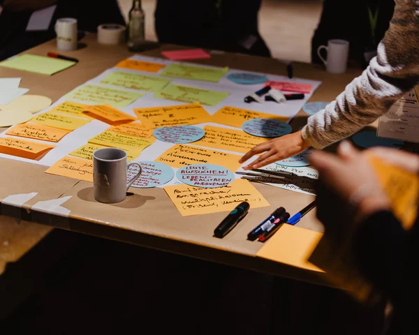 Post-Its, Papiere und Stifte sind auf einem Tisch