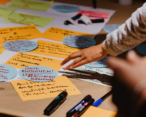 Post-Its, Papiere und Stifte sind auf einem Tisch