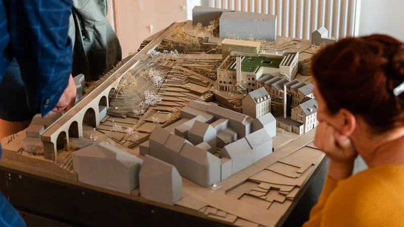 Menschen schauen auf das Modell vom BOB Campus