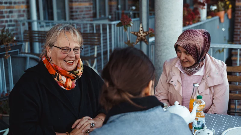 Menschen essen und reden draußen an einem Tisch